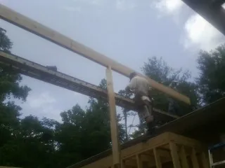 Carpenter setting a ridge beam over a new addition frame — Ice Dam Removal by Roofing Brothers in Stafford